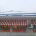 Snö har glidit under snörasskydden - de har frysit i rännan - rännan fungerar inte - risk finns att rännan slits lös från taket och underbrädorna får vattenskador.